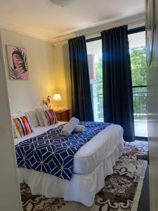 a bedroom with a bed with a blue and white comforter at Guildford room near Cafe and Train in Guildford