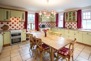 een keuken met een houten tafel en stoelen bij Halyon Village in Greencastle