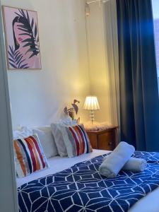 a bedroom with a bed with a blue comforter at Guildford room near Cafe and Train in Guildford +2 photos