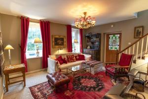 a living room with a couch and chairs and a chandelier at Halyon Village in Greencastle