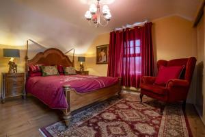 een slaapkamer met een bed, een stoel en een kroonluchter bij Halyon Village in Greencastle