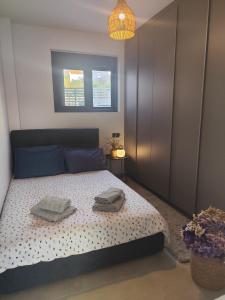 a bedroom with a bed with two towels on it at Αriadne in Porto Rafti