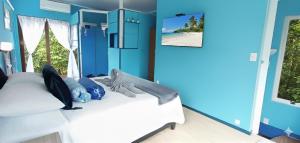 a bedroom with a bed with blue walls and a window at Casa Gloria con Piscina - Jacuzzi exterior climatizada Relax Playa in Punta del Este