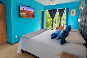 a bedroom with a large bed with blue walls at Casa Gloria con Piscina - Jacuzzi exterior climatizada Relax Playa in Punta del Este +29 photos