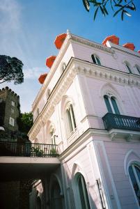 a white building with red flowers on top of it at Il Capri Hotel in Capri