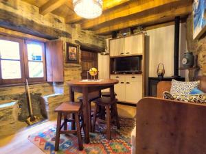 a kitchen with a table and chairs in a room at Casa do Talasnal by Refúgio ao Luar in Talasnal