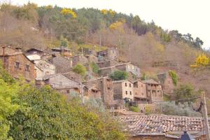 a group of houses on a hill with a train at Casa do Talasnal by Refúgio ao Luar in Talasnal