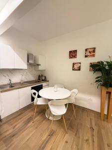 a white kitchen with a white table and chairs at Ama Esclusive Spa Florence in Florence +35 photos