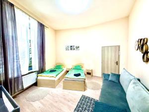 a room with two beds and a couch and a window at Oasis Valley in Karlovy Vary