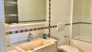 Un baño con lavabo, inodoro y espejo. en Le Murrine Frontemare Apartment Sea View 503, en Chioggia