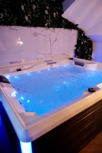 Saint-Yzan-de-SoudiacJungle Room et Jacuzzi的客房内的大浴缸里装有蓝色的水