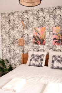 Saint-Yzan-de-SoudiacJungle Room et Jacuzzi的卧室配有白色的棕榈树壁纸 更多76张照片