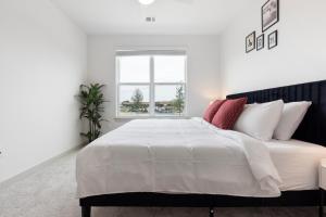 a white bedroom with a large white bed with red pillows at Large Lively Apt in San Marcos +63 photos