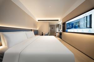 Ένα ή περισσότερα κρεβάτια σε δωμάτιο στο Huanman Hotel Qingdao Zhanqiao Zhongshan Road Metro Station Branch