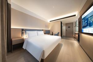 Ένα ή περισσότερα κρεβάτια σε δωμάτιο στο Huanman Hotel Qingdao Zhanqiao Zhongshan Road Metro Station Branch