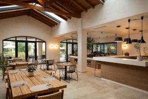 a restaurant with tables and chairs and a kitchen at The Yard Corfu Boutique Hotel and Spa in Moraitika