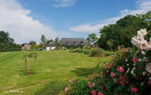 a house in the middle of a field with flowers at La Forcerie maison d'hôtes et spa in Châtelais