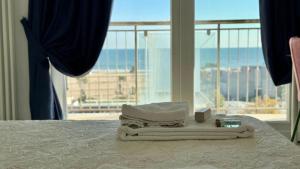 a bedroom with a bed with towels and a window at Le Murrine Frontemare Apartment Sea View 503 in Sottomarina