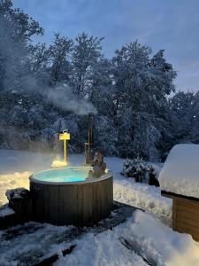 a man in a hot tub in the snow at Oleksowiczówka in Zborowice