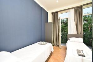 two beds in a room with blue walls and a window at tumanyan 38 guest hause in Yerevan +23 photos