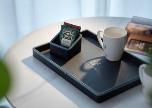 Huanman Hotel Changsha Wuyi Square South Gate Metro Station Branch في تشانغشا: صينية مع كوب قهوة على طاولة