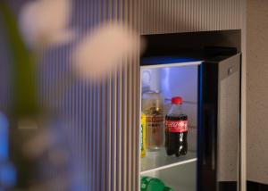 Huanman Hotel Changsha Wuyi Square South Gate Metro Station Branch في تشانغشا: ثلاجة صغيرة تحتوي على زجاجة صودا بداخلها +12 صورة