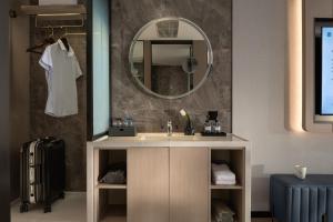 Huanman Hotel Changsha Wuyi Square South Gate Metro Station Branch في تشانغشا: حمام مزود بحوض ومِرآة