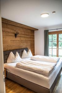 上陶恩Dorfplatzl Loft的一间卧室设有一张带木墙的大床
