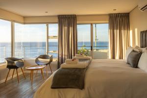 una camera da letto con un letto grande con vista sull'oceano di Ocean View Properties - Apartment 701 a Città del Capo
