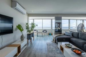 un soggiorno con un divano e un tavolo di Ocean View Properties - Apartment 701 a Città del Capo