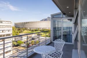 un balcone con tavolo e sedie su un edificio di Ocean View Properties - Apartment 701 a Città del Capo