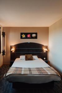 um quarto com uma cama grande e duas lâmpadas em Hôtel Akena Caudry Cambrai em Caudry mais 35 fotografias