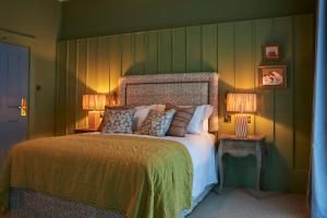 um quarto com uma cama grande com duas lâmpadas em The Potters Heron - A Heartwood Inn em Romsey