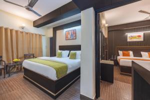 una habitación de hotel con dos camas y un escritorio en Kasauli Residency, en Kasauli