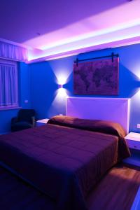 a bedroom with a bed with purple lights on it at Hotel Miravalle in Naples