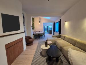ein Wohnzimmer mit Couch und Flachbildfernseher in der Unterkunft Spacious 5-room house near Brussels with private parking in Steenokkerzeel