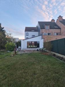ein weißes Haus mit einem Rasen davor in der Unterkunft Spacious 5-room house near Brussels with private parking in Steenokkerzeel
