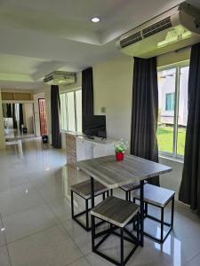 a living room with a wooden table and chairs at Kaengkrachan Diamond Green Resort in Ban Song Phi Nong