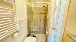 a bathroom with a toilet and a glass shower at Appartamento Cristallo - Affitti Brevi Italia in Bardonecchia +10 photos