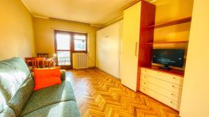 a living room with a couch and a tv at Appartamento Cristallo - Affitti Brevi Italia in Bardonecchia