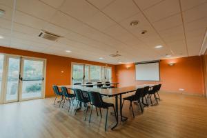 uma sala de conferências com uma mesa longa e cadeiras em Hôtel Akena Caudry Cambrai em Caudry