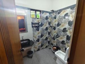 a bathroom with a black and white shower curtain at Leaf Garden Retreat in Varkala