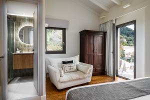 a bedroom with a bed and a chair and a mirror at Ermioni Countryside Residence by Konnect, Agios Markos in Ágios Márkos +15 photos