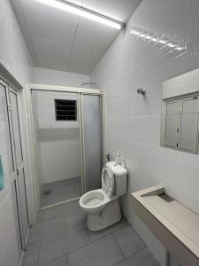 a white bathroom with a toilet and a shower at Silliau curve stays in Siliau