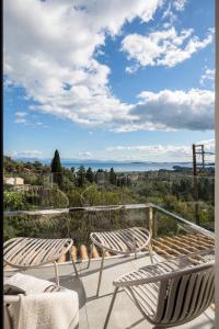 a balcony with two chairs and a view of the ocean at Ermioni Countryside Residence by Konnect, Agios Markos in Ágios Márkos