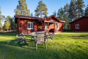 a log cabin with a table and benches in the grass at Sunne Hembygdsgård B&B in Sunne