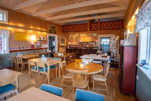 a restaurant with wooden floors and tables and chairs at Sunne Hembygdsgård B&B in Sunne