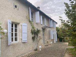 RonsenacChez Gargatte, 12personnes , piscine chauffée , FR的白色的房子,有蓝色百叶窗和车道