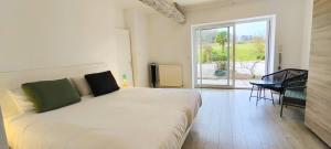 a white bed in a room with a large window at Chez Gargatte, gîte 4 chambres, 12personnes , piscine privée chauffée de mai à septembre , FR in Ronsenac +37 photos