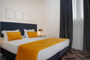 um quarto com uma cama grande com travesseiros amarelos em Glória Suites Hotel em Lisboa
